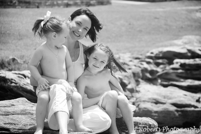 Mother and her daughters on the rocks at the beach - family portrait photography sydney
